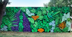 a large mural on the side of a building with flowers and butterflies painted on it