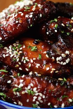 a bowl filled with chicken wings covered in sesame seeds