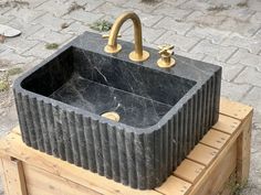 a sink made out of concrete sitting on top of a wooden crate