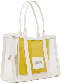 Transparent PVC tote. · Buffed faux-leather trim in white throughout · Twin rolled shoulder straps · Logo and text embossed at face · Logo patch at back face · Bumper studs at base · Open throat · Zip pocket and card slot at interior · H11.5 x W16.5 x D6.5 Supplier color: White White Shopping Bag With Logo Strap, White Bag With Logo Strap For Shopping, White Bags With Logo Strap For Shopping, Modern White Bags With Leather Trim, Marc Jacobs Tote Bag, Marc Jacobs Tote, Craft Tote Bag, Face Logo, Large Tote Bag