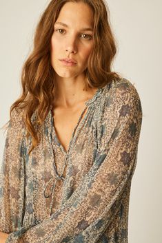 a woman with long hair wearing a blouse