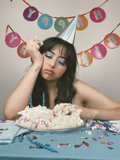 a woman sitting in front of a birthday cake