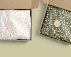 two open boxes with floral designs on them, one is green and the other is white