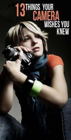 a woman holding a camera in her right hand and looking at the camera with an intense look on her face