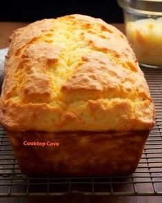 a loaf of bread sitting on top of a cooling rack next to a glass container