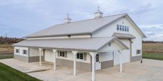 a large white barn with two stalls on the side