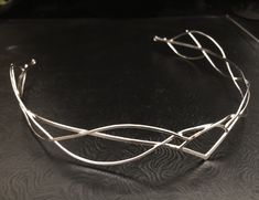 I have fabricated a sterling silver Celtic and Elvish inspired bridal tiara which is designed to be worn for a wedding, a Renaissance event, or hand-fasting ceremony. An artisan circlet with a Middle Earth feel! This piece can be unisex and comes without a gemstone. This piece will fit 3/4's around the head and is tied off, in the back, by an elastic jeweler's cord so that it will remain snug and in place while in motion. This works better than using a chain link, which can leave a circlet too t Adjustable Crown Design Headpiece For Weddings, Elegant Silver Headpieces For Gifts, Elegant Silver Headband For Wedding, Silver Crown Headpiece For Wedding, Elegant Silver Headpiece With Structured Crown, Adjustable Silver Crown Headband, Elegant Silver Headpiece With Teardrop Crown, Silver Teardrop Crown Headpiece, Elegant Silver Teardrop Crown Headpiece