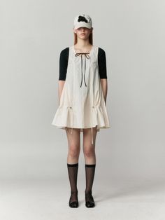 This dress is a sleeveless tunic with a wide, round neckline that provides a comfortable and relaxed fit around the shoulders and neck. The silhouette is an A-line shape, flaring gently from the shoulders to the hem, offering a flowy and flattering drape. It features adjustable drawstrings at the lower sides, which can be cinched to create a ruched effect and alter the garment's shape. The fabric appears to be lightweight and probably breathable, making it suitable for warm weather or layering.- The dress suggests versatility as it could pair well with a variety of other shades and patterns.- The absence of sleeves and the airy cut make it ideal for summer days or as a layering piece over long sleeves for cooler weather.- The hem of the tunic is finished with a ruffle, adding a playful and Flowy Fabric Aesthetic, Beige A-line Sleeveless Dress For Daywear, Spring Sleeveless Pinafore Dress With Tie Straps, Casual Flared Hem Summer Dress, Spring Sleeveless Sundress Pinafore, Casual Sleeveless Pinafore Dress With Ruffles, Sleeveless Pinafore Dress For Daywear, Cotton Pinafore Dress For Daywear, Summer Sundress Pinafore Dress