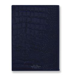 a dark blue alligator skin notebook with the cover open to show it's croct pattern