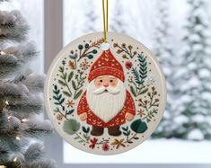 a christmas ornament hanging from a tree in front of a snow covered window