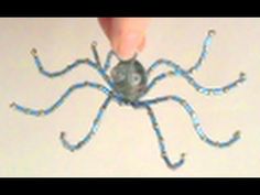 a spider made out of beads is being held by someone