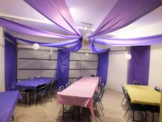 a banquet room with purple drapes on the ceiling