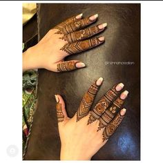 two hands with henna tattoos on them and one is showing off the intricate design