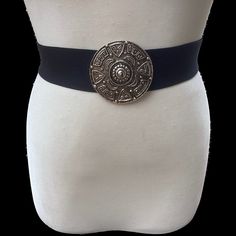 Vintage women's wide black cinch stretch belt with big silver Celtic medallion buckle ITEM DESCRIPTION: Offering this gorgeous designer fashion wide black cinch belt.  This belt features a big round silver tone metal textured buckle with a Pagan or Egyptian style symbolism. The belt strap is a high quality wide stretch material. The buckle and hook part are signed: "1989 Pearl" and "Pearl PAT 273345". MEASUREMENTS: This classy mod belt measures approximately 26 inches long (full length, un-stret Elegant Black Belt With Antique Buckle, Black Party Belts With Antique Buckle, Black Party Belt With Antique Buckle, Formal Black Antique Belt Buckle, Antique Black Belt Buckles For Festivals, Vintage Black Belt With Antique Buckle, Vintage Black Belt With Removable Buckle, Belt Buckle For 2.5” Wide Belt, Vintage Black Belt Buckles With Brass Detail