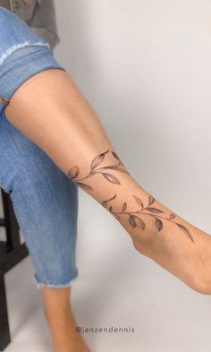 a woman's foot with a flower tattoo on her left leg and the bottom part of her legs