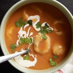 a bowl of soup with dumplings and garnishes on the top is ready to be eaten