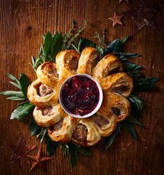 christmas pastries with cranberry sauce and holly leaves on a wooden table top