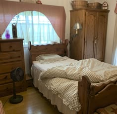 a bedroom with a bed, dresser and window