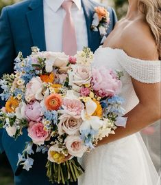 the bride and groom are standing close together holding their wedding bouquets in their hands