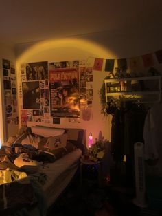 a bed room with a neatly made bed and lots of posters on the wall above it