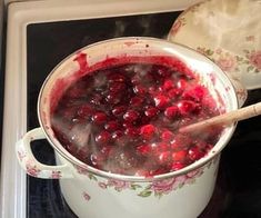 a pot filled with cranberry sauce on top of a stove