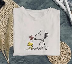 This charming Snoopy embroidered T-shirt captures a heartwarming moment between Snoopy and Woodstock. The design features Woodstock sweetly offering a flower to Snoopy, adding an adorable touch of friendship and love. Perfect for fans of the beloved Peanuts characters, this tee is both cute and timeless. The detailed embroidery brings the scene to life, making it a standout piece in any wardrobe. Crafted from soft, high-quality fabric, this T-shirt is perfect for casual outings, lounging, or showing off your love for Snoopy and Woodstock. Whether you're treating yourself or looking for a thoughtful gift, this shirt is sure to bring a smile to any Peanuts fan. Celebrate the joy of friendship with this sweet and playful Snoopy T-shirt! Funny Snoopy, Snoopy Und Woodstock, Friendship Shirts, Snoopy Gifts, Friend Shirt, Snoopy Shirt, Snoopy T Shirt, T-shirt Broderie, Peanuts Characters