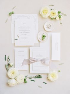 the wedding stationery is laid out with flowers