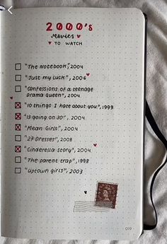 an open notebook with writing on it and a rubber stamp that says 2000's makes to watch