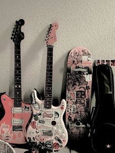 three guitars are lined up next to each other with stickers all over the guitar body