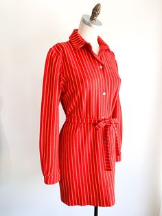 Vibrant poppy with yellow stripes throughout mini shirt dress with button front, collar and tie. Fabric: WoolLabel: Rudi GernreichFit: S/MEra: 1960's Measurements: Bust 38" Shoulder 16.5" Sleeve 23.5" Length 32" Waist 36" Hips 37" Belt 1" x 59" Condition: Very good. One pin hole on back of collar and one tiny snag on left shoulder (see photos). Dress has been shortened. Fitted Striped Long Sleeve Shirt Dress, Classic Striped Long Sleeve Shirt Dress, Fitted Striped Shirt Dress For Daywear, Classic Striped Button-up Shirt Dress, Classic Striped Shirt Dress For Work, Striped Collar Shirt Dress, Daywear Shirt Dress With Striped Collar, Striped Shirt Dress With Buttons For Work, Fitted Striped Shirt Dress For Fall