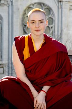 a woman in a red and yellow outfit sitting on a bench