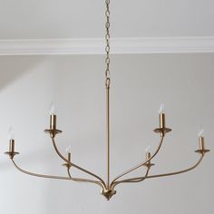 a chandelier hanging from the ceiling in a room with white walls and flooring