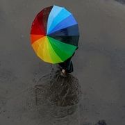 a colorful umbrella sitting on top of a puddle