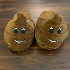 a pair of brown slippers with eyes and smiling faces on top of wooden floor