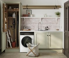 a washer and dryer sitting in a kitchen next to an open cabinet door