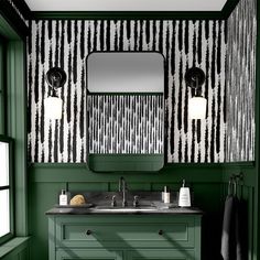 a bathroom with green painted walls and black and white wallpaper, along with two sinks