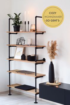 a shelf with candles, plants and pictures on it