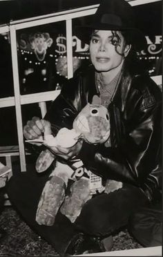 black and white photograph of michael jackson holding a teddy bear