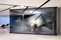 an office with glass walls and black chairs