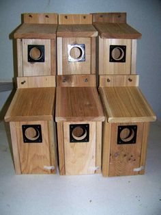 several wooden birdhouses stacked on top of each other with holes in the front and sides