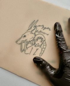 a person's hand with a tattoo on it next to a piece of paper