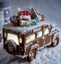 an old fashioned car covered in snow with presents on top