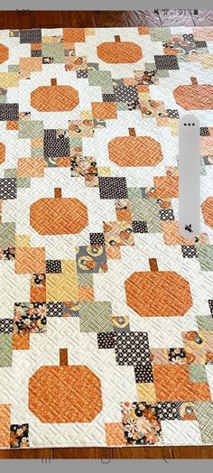 a quilted table topper with pumpkins on it and an electrical outlet plugged in