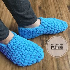 a person wearing blue crocheted slippers on top of a wooden floor