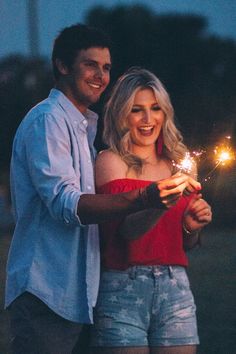 a man and woman holding sparklers in their hands