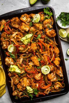 chicken fajita with peppers, onions and avocado on a baking sheet