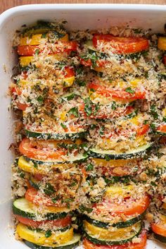 a casserole dish with zucchini, tomatoes and parmesan cheese