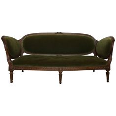 an antique style couch with green velvet upholstered