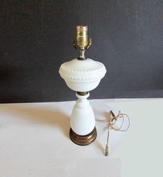 a white table lamp sitting on top of a counter next to a pair of keys