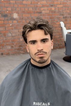 This brief hairstyle showcases textured waves that sit naturally on top of the head, creating a look that's both relaxed and fashionably composed. The sides are trimmed shorter to enhance the volume and movement of the longer, wavy locks up top. It's a versatile cut that exudes a laid-back charm while maintaining a sharp and - Click to see more of 32 Essential Short Flow Haircuts for the Well-Dressed Gentleman and follow us for more hairstyle ideas. // Photo Credit: Instagram @olliewiness Short Side Part Haircut, Mens Wavy Side Part, Long On Too Short On Sides Men, Medium Top Short Sides Men, Short Sides Longer Top Hair Men, Short Pushed Back Hair Men, Mens Haircuts Fade Long On Top, Side Part With Beard, Man Haircut Wavy Hair